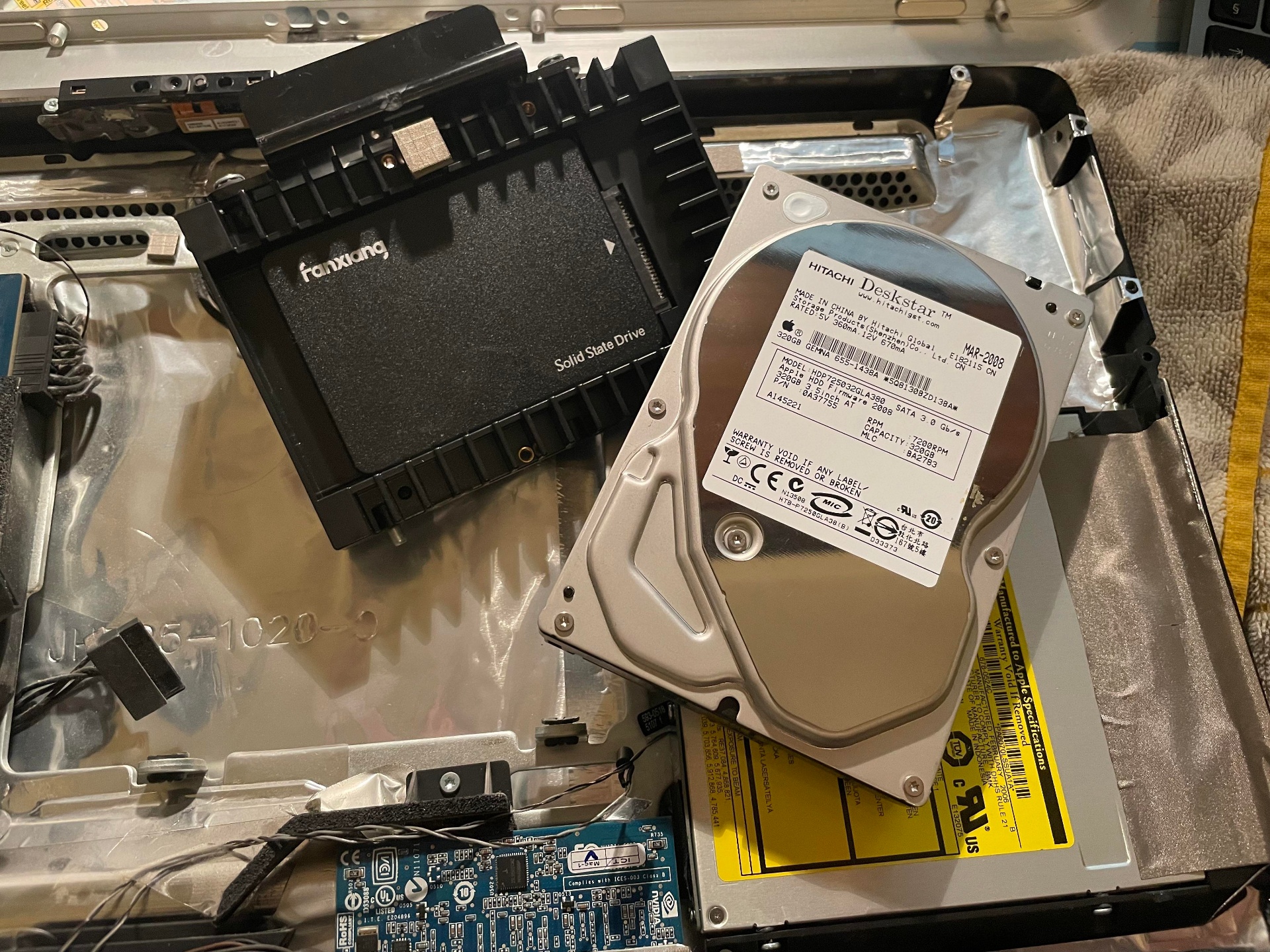 Alte iMac Hitachi HDD neben moderner SSD beim Tausch