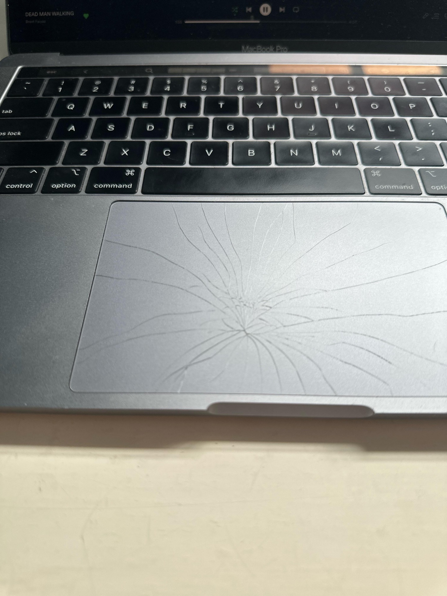 Beschädigtes MacBook Pro Trackpad mit Glasbruch